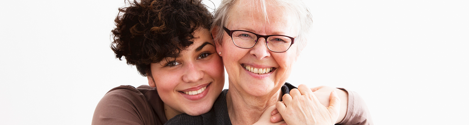 young woman embracing senior woman, both happy together